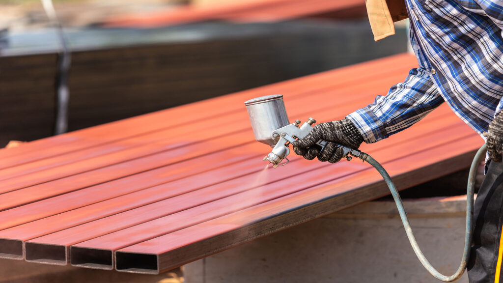 powder coating spray gun spraying a metal gate