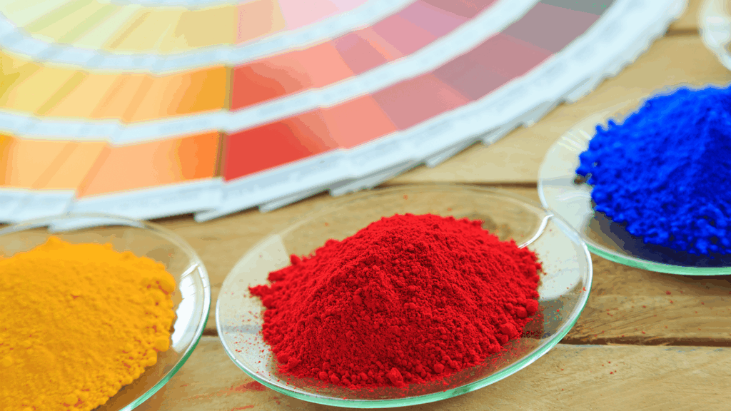 yellow and red color chart next to yellow, red, and blue piles of powder